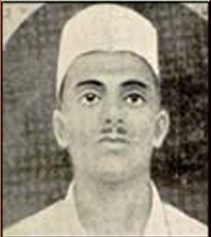 Black-and-white studio photograph of Sukhdev Thapar wearing a white cap and collarless shirt