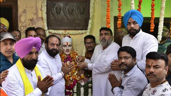 A commemoration at a memorial bust of Sukhdev Thapar, with a relief plaque of the three martyrs behind it